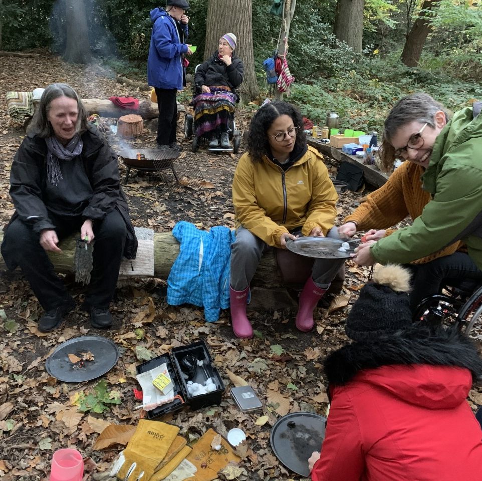 People sitting on logs doing crafts during a creatives playtime session